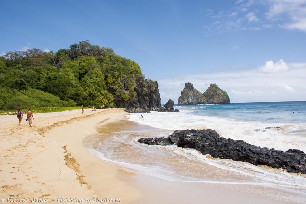 Imagem de poucos turistas nas areias da Praia Cacimba do Padre.